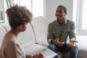 Teen discusses treatment programs while sitting on couch next to therapist